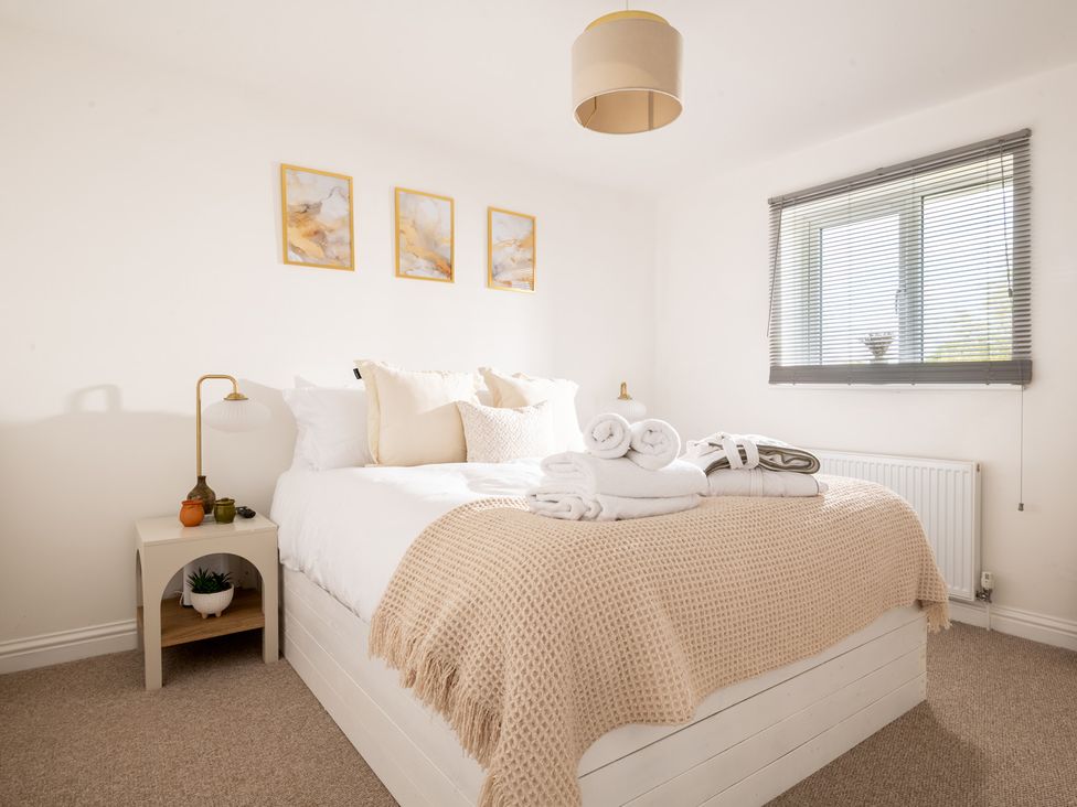 A bedroom with a bed and side table at Hambledon Hill Cottage in Blandford Forum