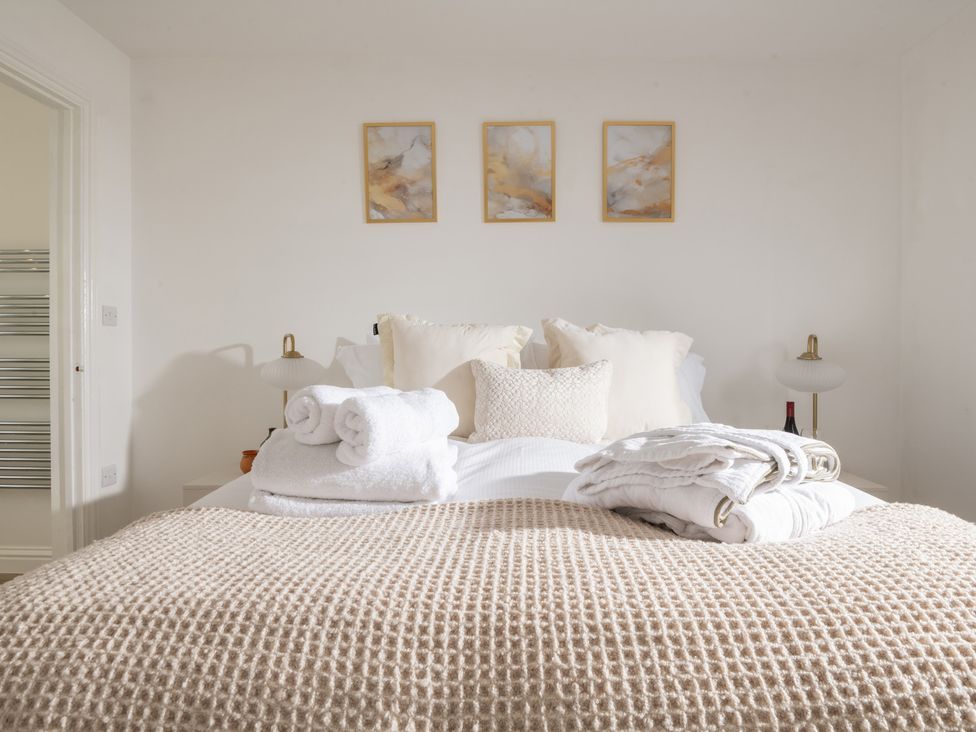 A bedroom with a bed and pillows at Hambledon Hill Cottage in Blandford Forum