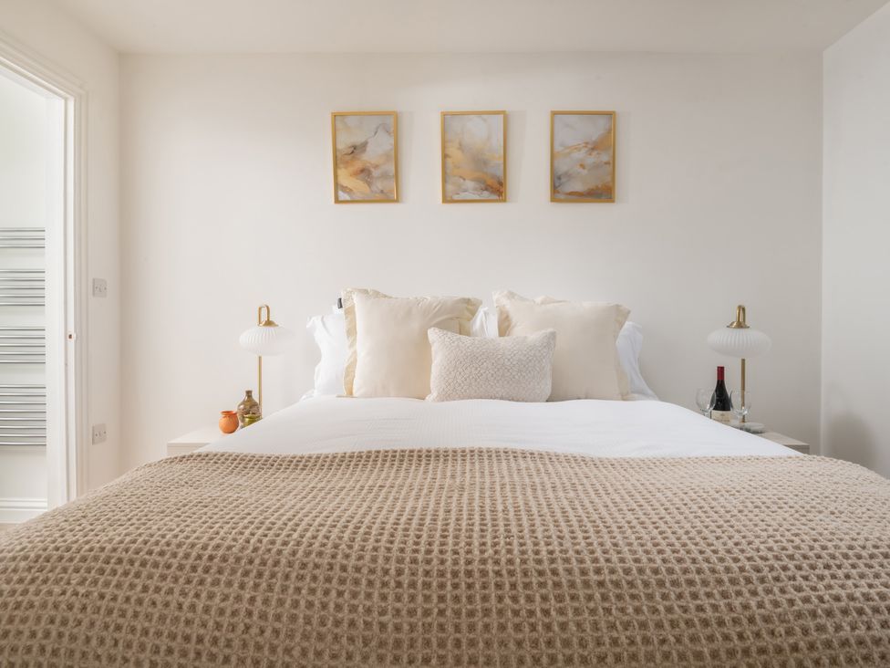 A bedroom with a bed and wall art at Hambledon Hill Cottage in Blandford Forum