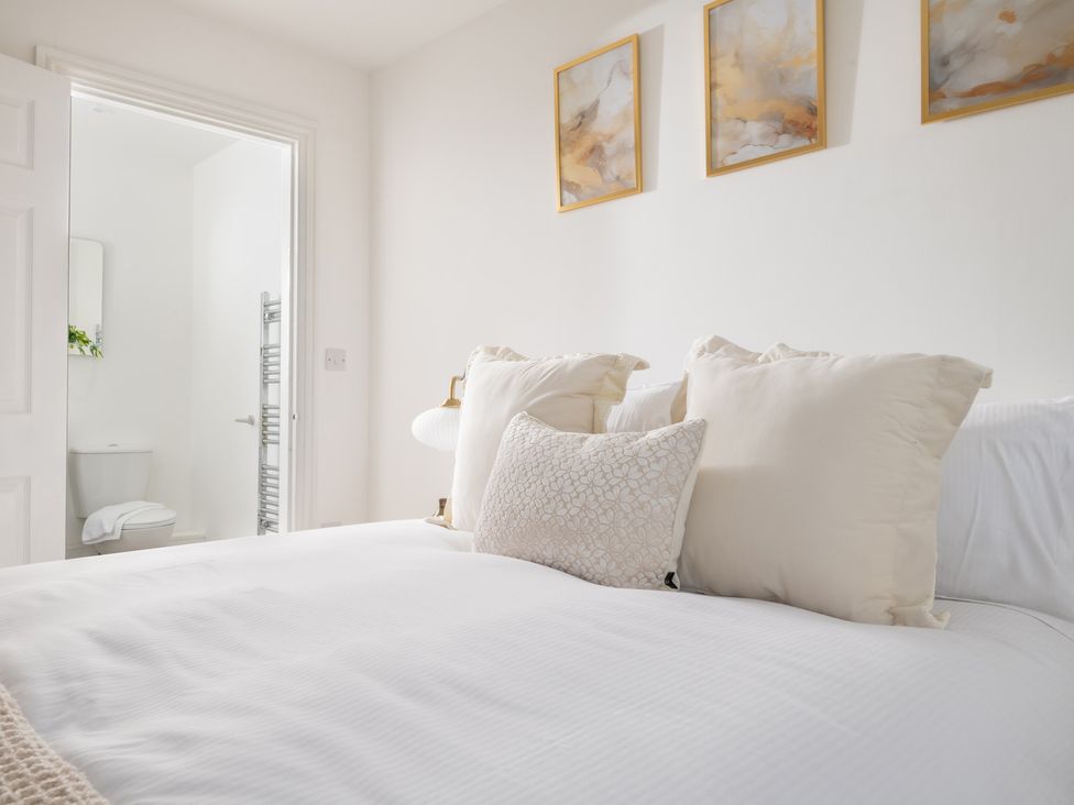 A bedroom with a bed and an adjoining bathroom at Hambledon Hill Cottage in Blandford Forum