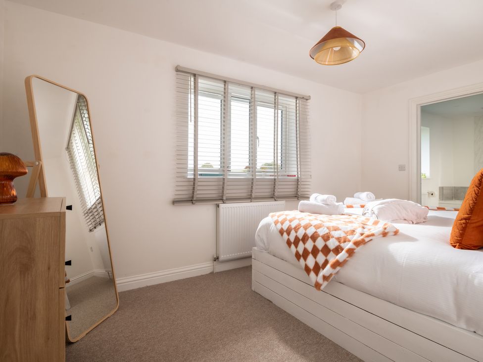 A bedroom with a bed and mirror at Hambledon Hill Cottage in Blandford Forum