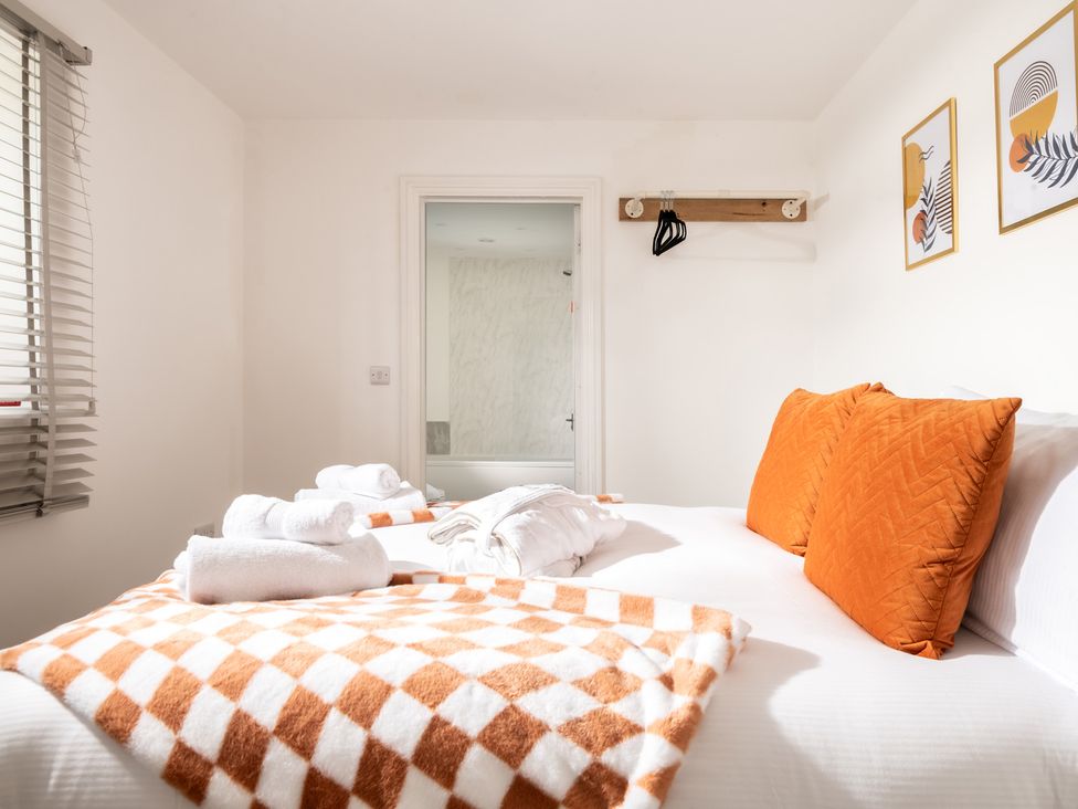 A bedroom with a bed and towels at Hambledon Hill Cottage in Blandford Forum