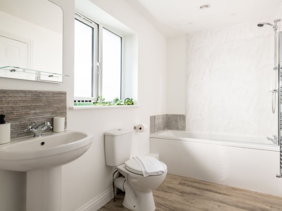 A bathroom with a sink, toilet, and bathtub at Hambledon Hill Cottage in Blandford Forum