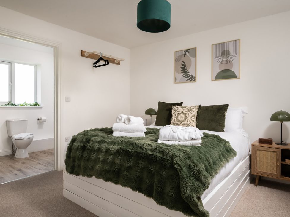 A bedroom with a bed and window at Hambledon Hill Cottage in Blandford Forum