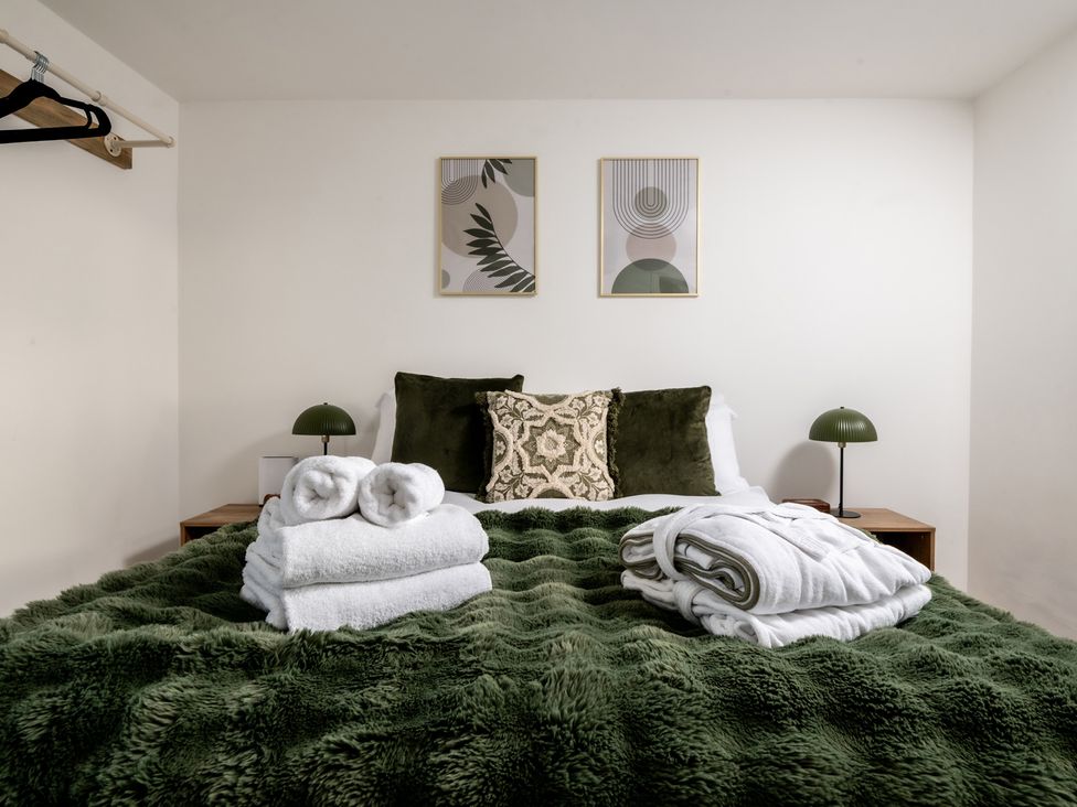 A bedroom with a bed and towels at Hambledon Hill Cottage in Blandford Forum