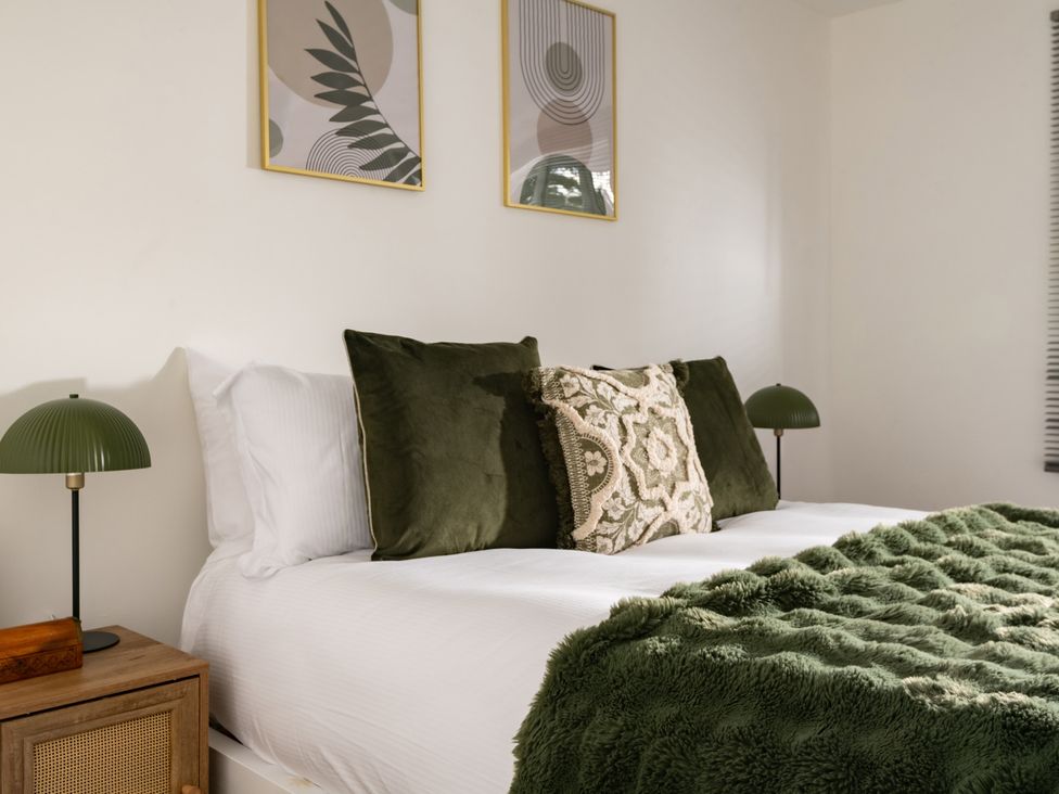 A bedroom with a bed and decorative pillows at Hambledon Hill Cottage in Blandford Forum