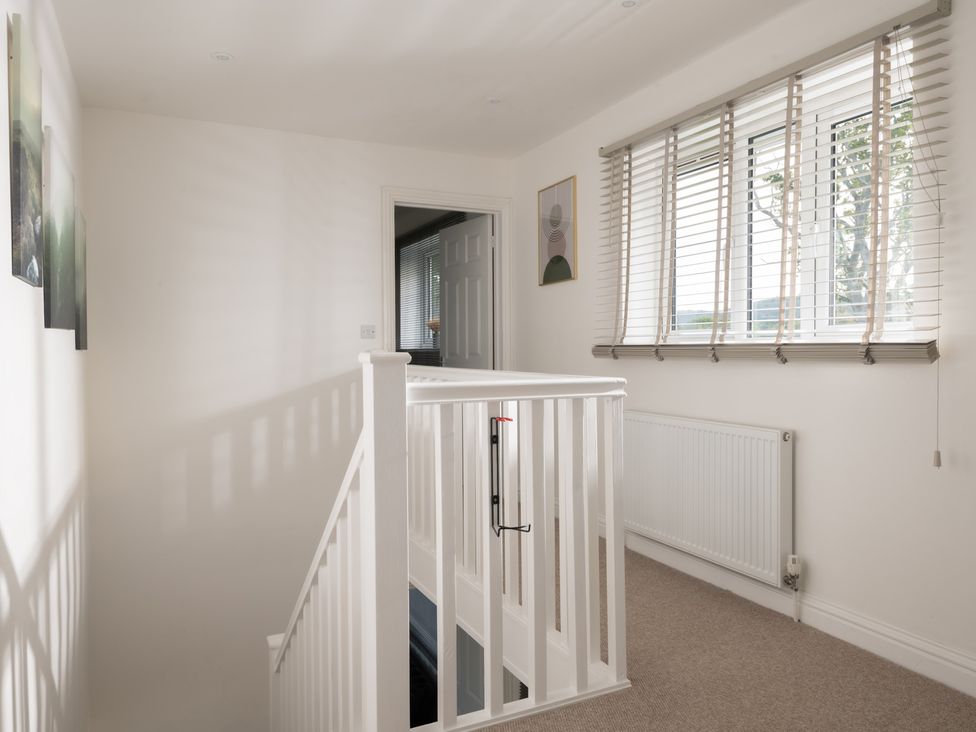 A hallway with a staircase and windows at Hambledon Hill Cottage Blandford Forum