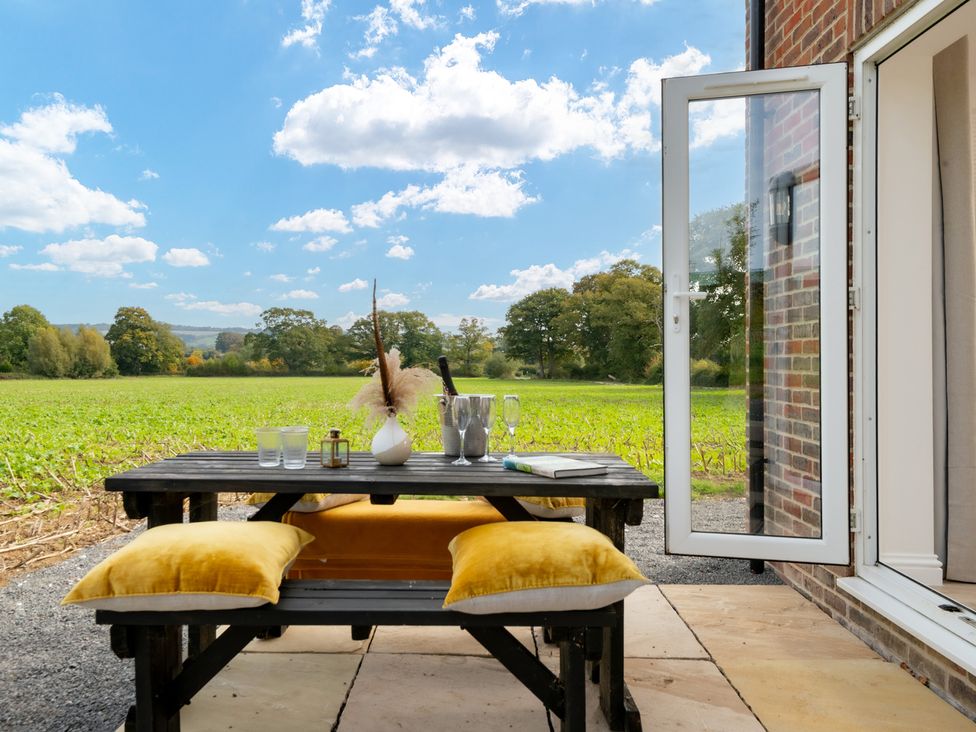 An outdoor dining area with a table and chairs at Hambledon Hill Cottage in Blandford Forum