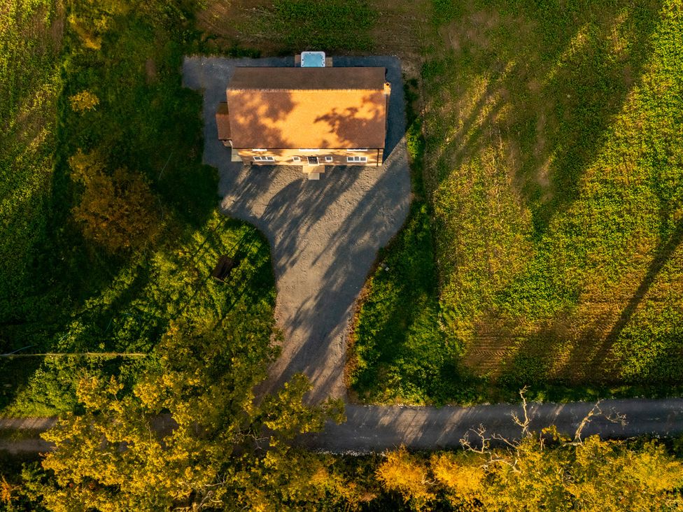 An aerial view of a house with a gravel driveway at Hambledon Hill Cottage in Blandford Forum