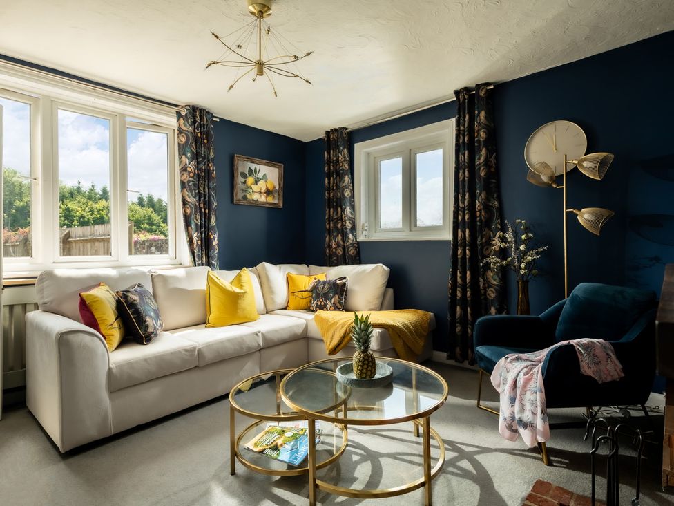 A living room with a sofa and table at Charming Countryside Cottage in Blandford Forum