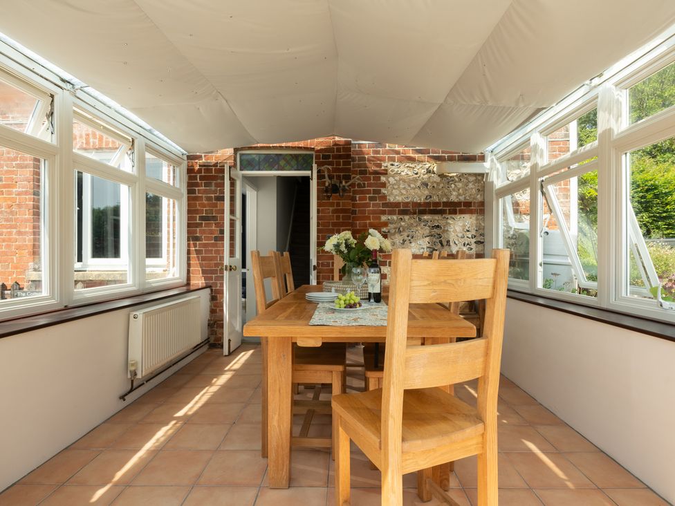 A dining area with wooden table and chairs at Charming Countryside Cottage in Blandford Forum