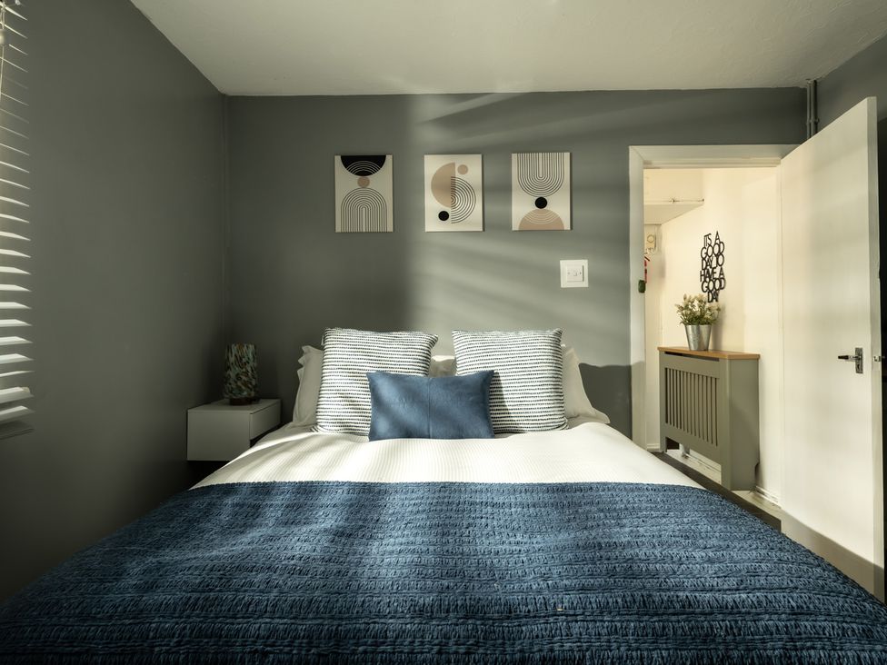 A bedroom with a bed and wall art at Charming Countryside Cottage in Blandford Forum