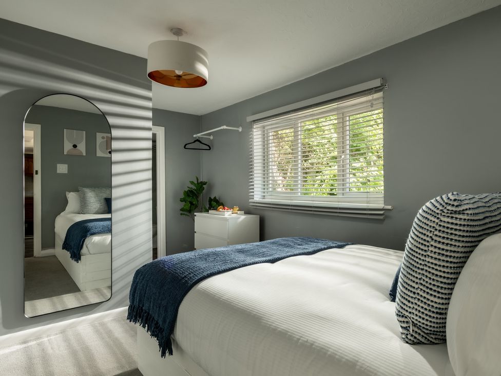 A bedroom with a bed and bedside table at Charming Countryside Cottage in Blandford Forum