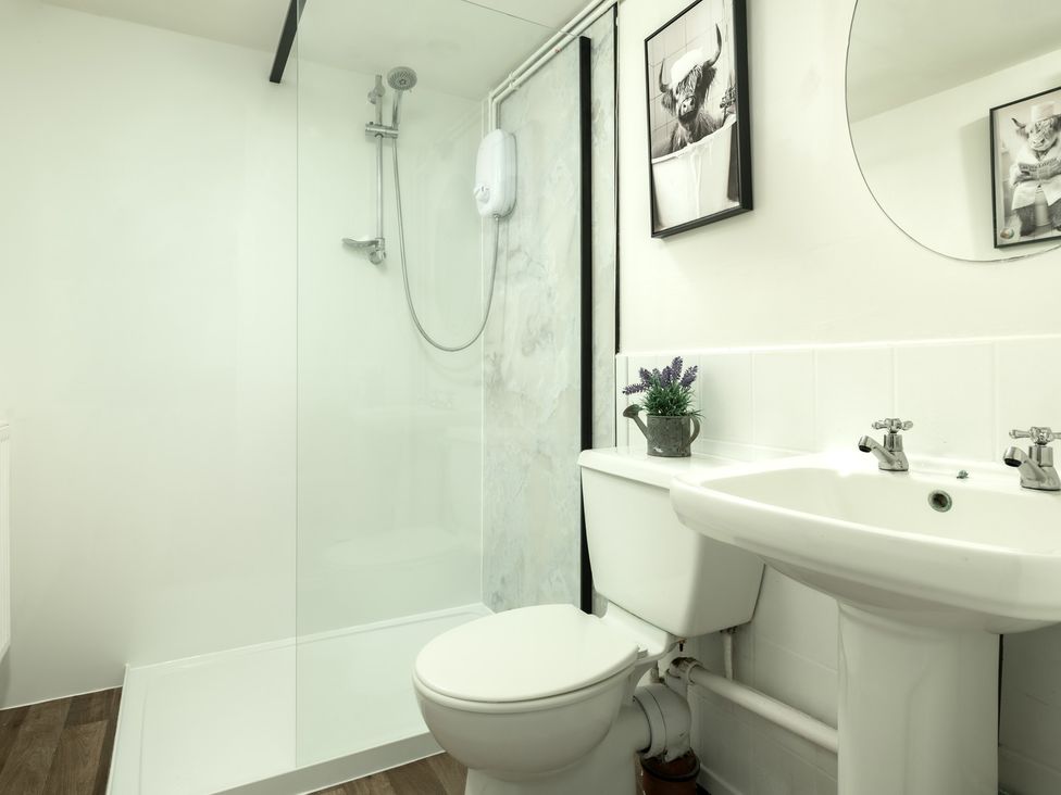 A bathroom with a shower, toilet, and sink at Charming Countryside Cottage in Blandford Forum