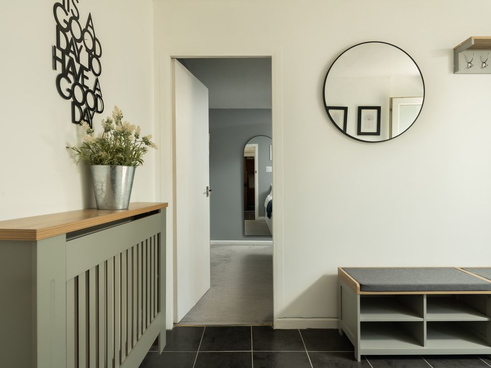 A hallway with a bench and a mirror at Charming Countryside Cottage in Blandford Forum