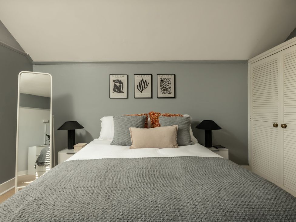 A bedroom with a bed and wall art at Charming Countryside Cottage in Blandford Forum