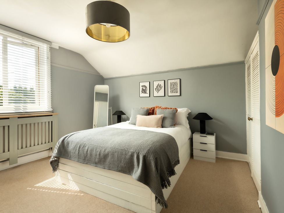 A bedroom with a bed and bedside table at Charming Countryside Cottage in Blandford Forum