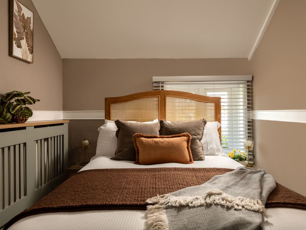 A bedroom with a bed and pillows at Charming Countryside Cottage in Blandford Forum