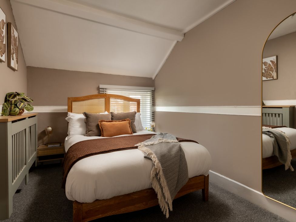A bedroom with a bed and nightstand at Charming Countryside Cottage in Blandford Forum