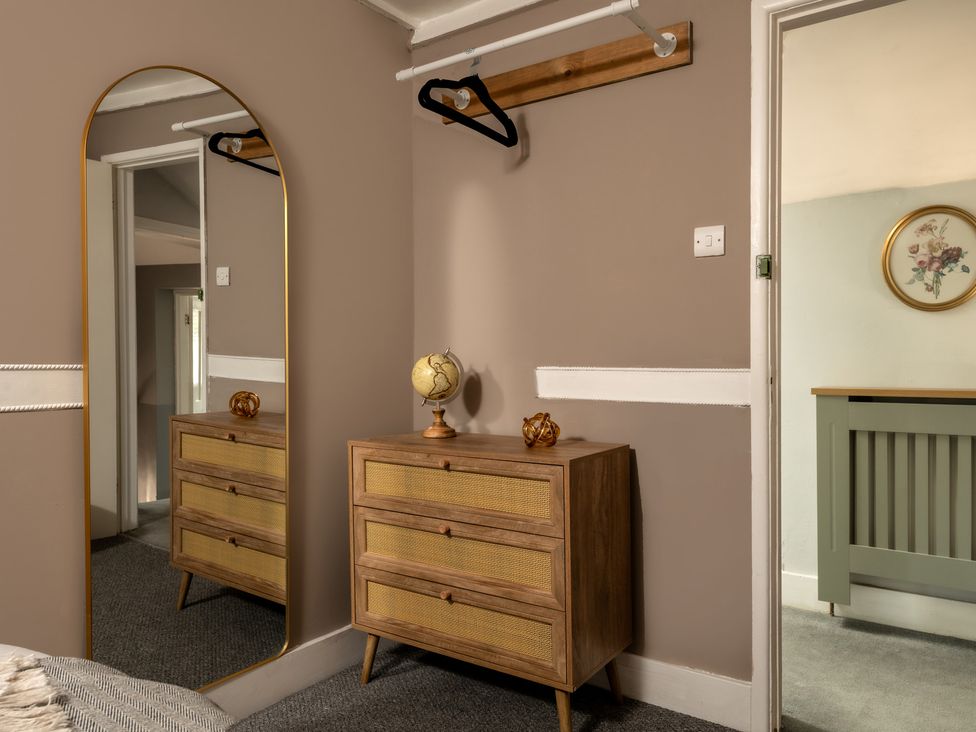 A bedroom with a dresser and mirror at Charming Countryside Cottage in Blandford Forum