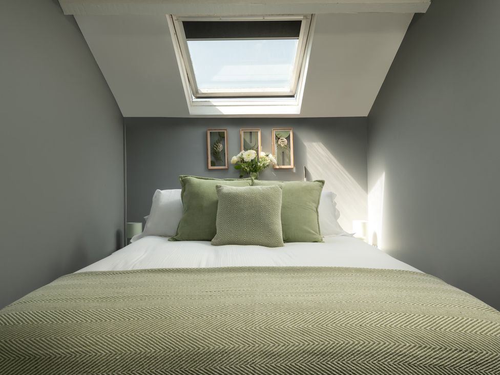 A bedroom with a bed and wall art at Charming Countryside Cottage in Blandford Forum