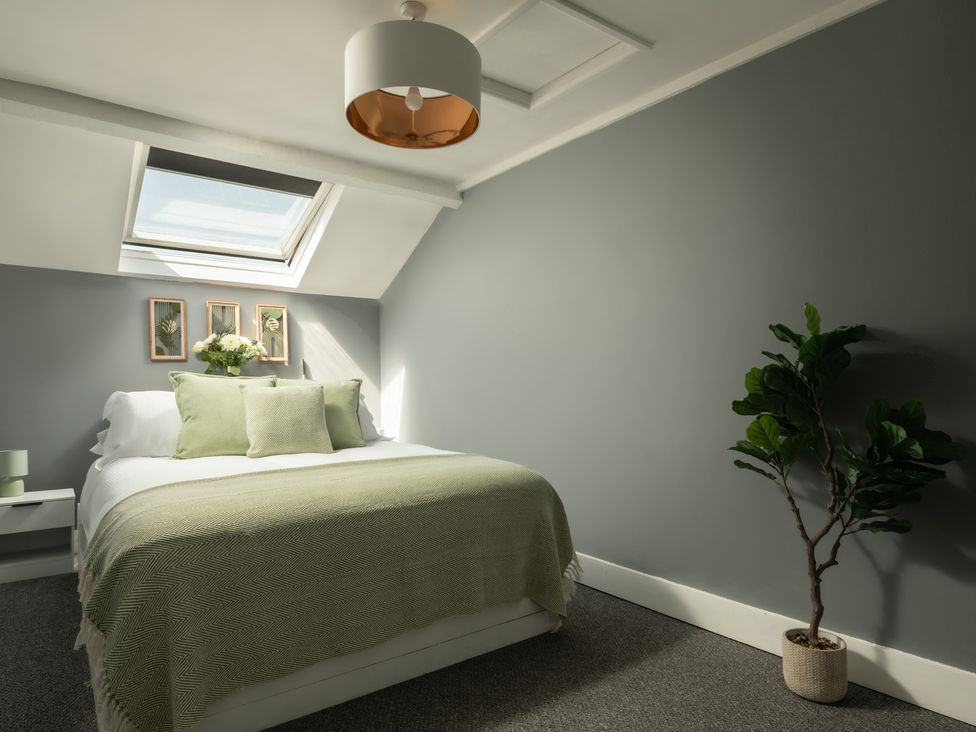 A bedroom with a bed and a plant at Charming Countryside Cottage in Blandford Forum