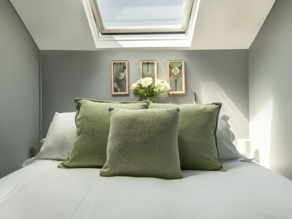 A bedroom with pillows and wall art at Charming Countryside Cottage in Blandford Forum