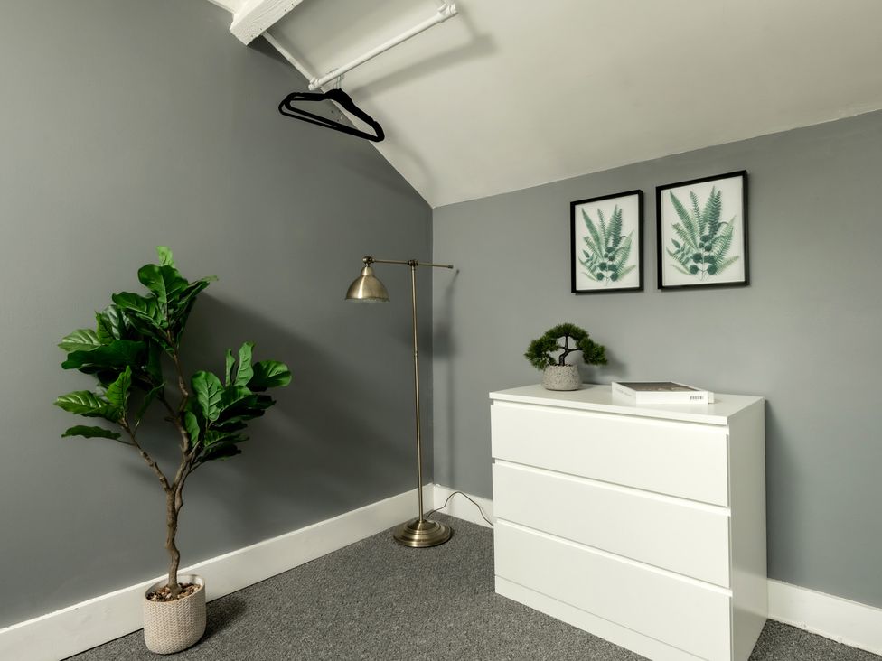 A bedroom with a dresser and lamp at Charming Countryside Cottage in Blandford Forum