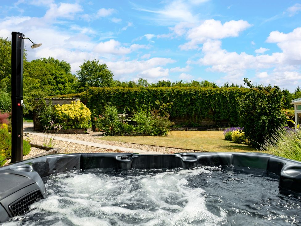 A garden with a hot tub and shower at Charming Countryside Cottage in Blandford Forum