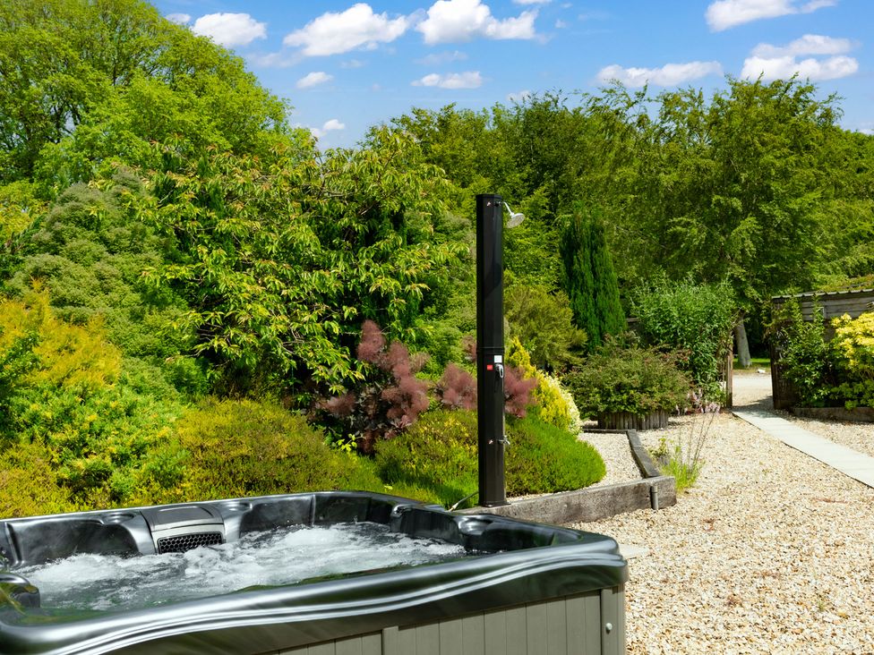 A hot tub and a shower in a garden at Charming Countryside Cottage Blandford Forum