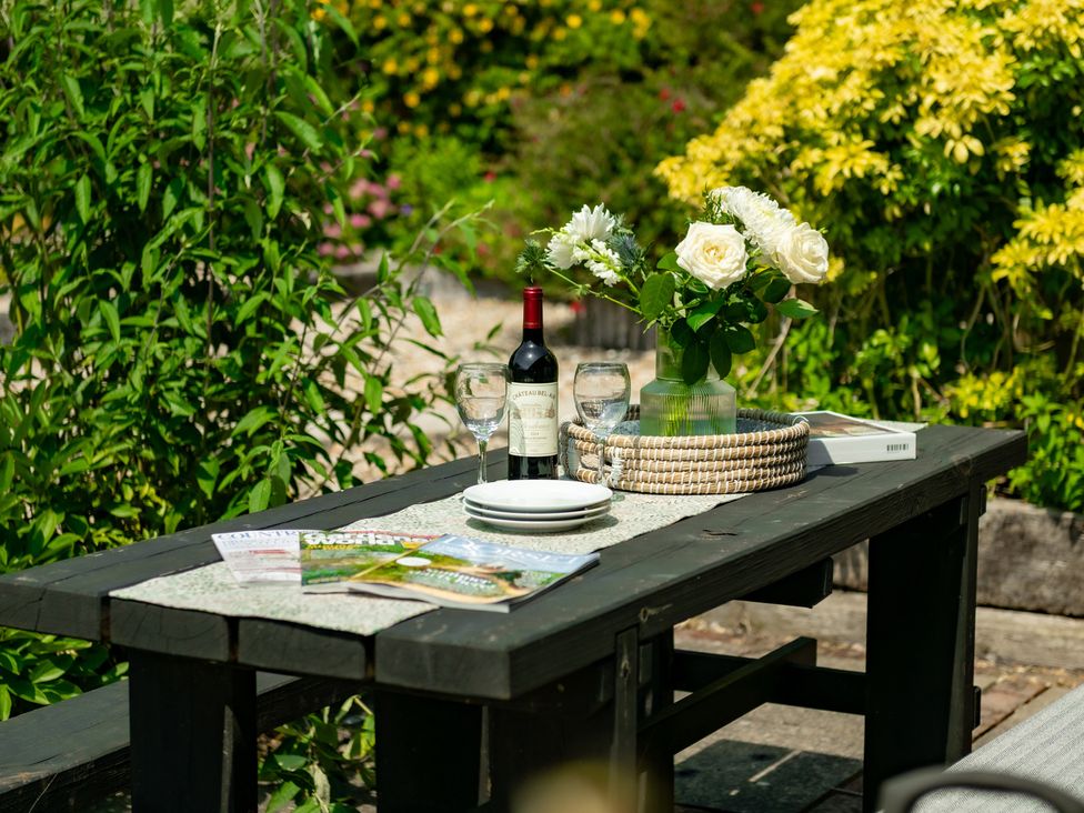 A table with wine, glasses, and flowers at Charming Countryside Cottage in Blandford Forum