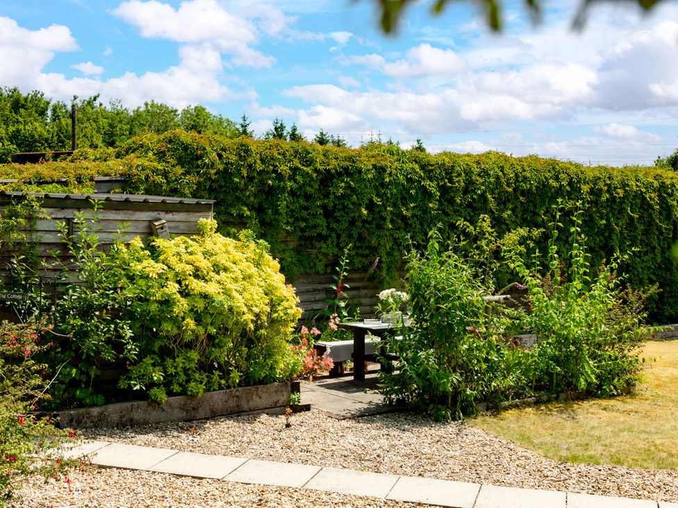 A garden with a sitting area and hedge at Charming Countryside Cottage in Blandford Forum
