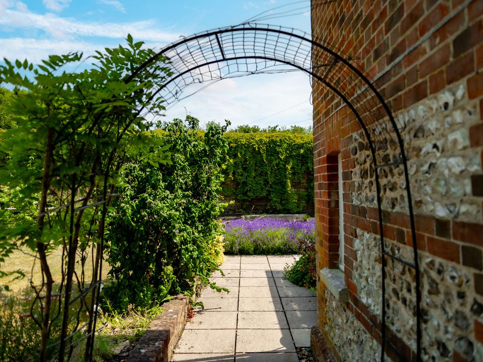 A garden with an archway and flowers at Charming Countryside Cottage in Blandford Forum