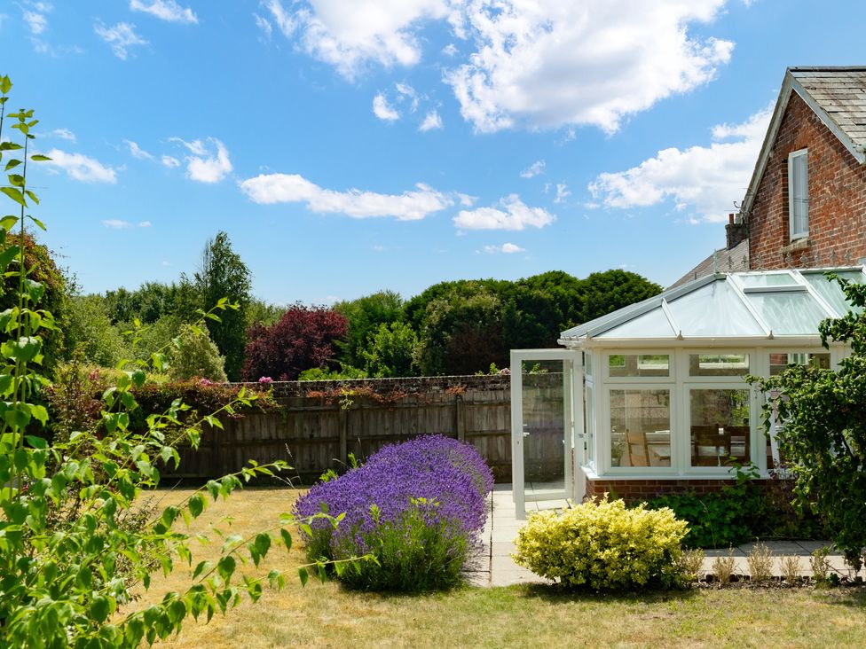 A garden with a conservatory and lavender at Charming Countryside Cottage in Blandford Forum