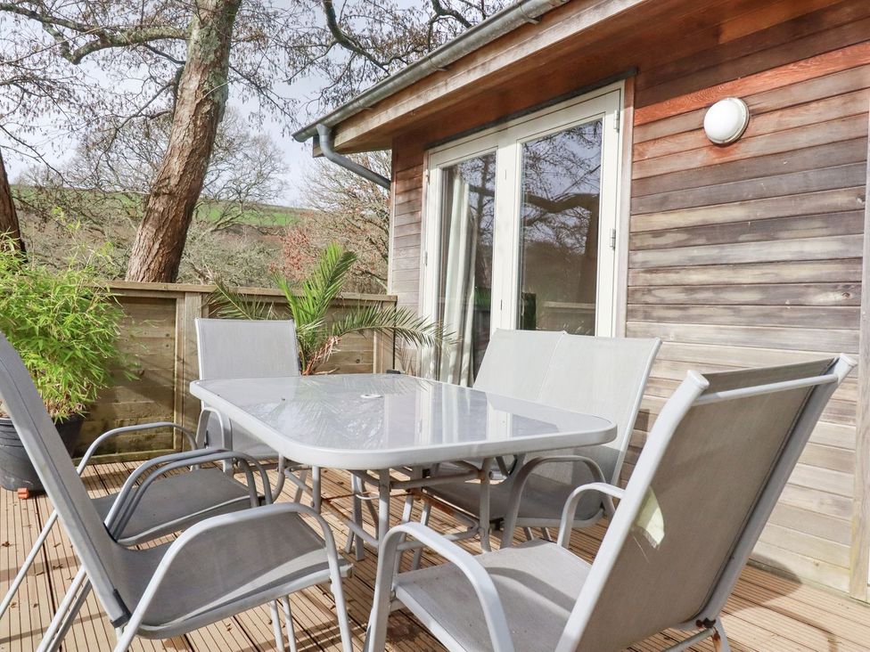 An outdoor dining area with a table and chairs at 1 Water's Edge 