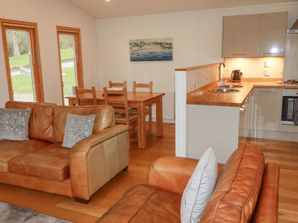 A living room with a sofa and dining table at 1 Water's Edge
