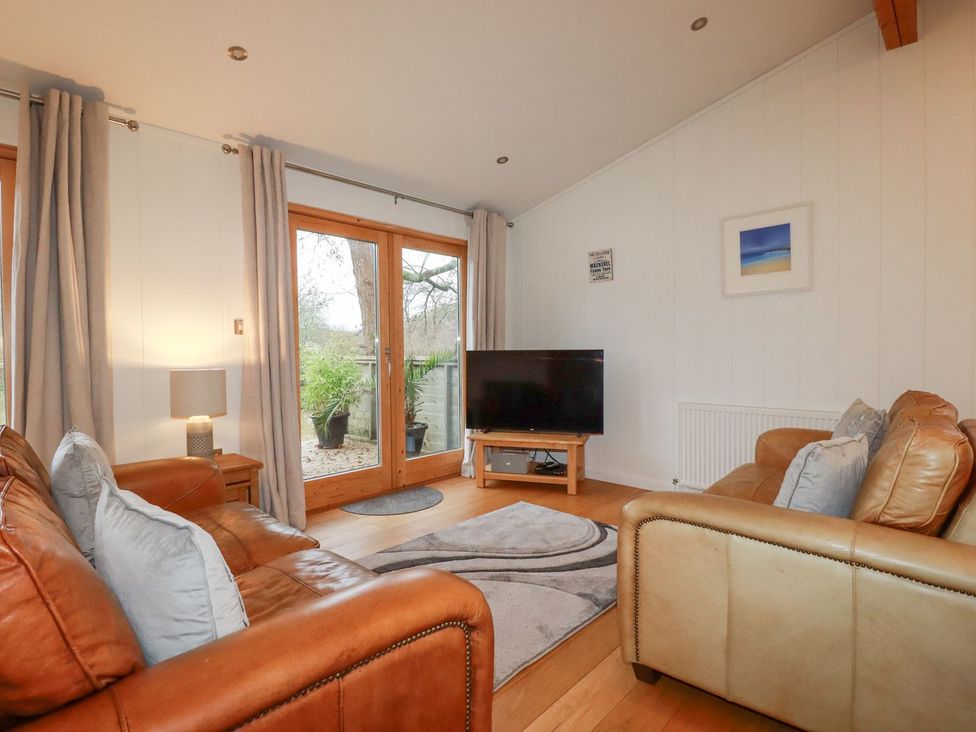 A living room with a tv and two sofas at 1 Water's Edge