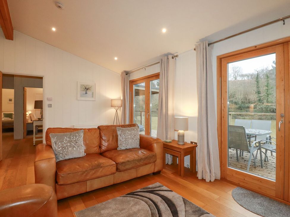 A living room with a sofa and a dining area at 1 Water's Edge 