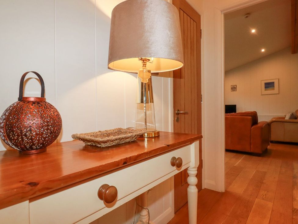 A hallway with a table and a lamp at 1 Water's Edge