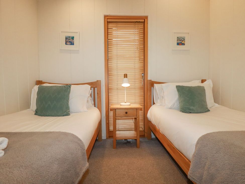 A bedroom with two beds and a bedside table at 1 Water's Edge