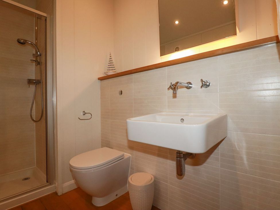 A bathroom featuring a shower, toilet, and sink at 1 Water's Edge