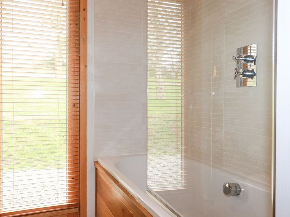 A bathroom with a bath tub and shower faucet at 1 Water's Edge
