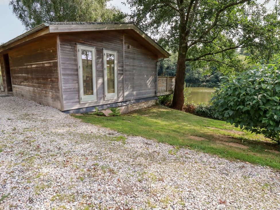 A wooden building with windows and gravel area at 1 Water's Edge 