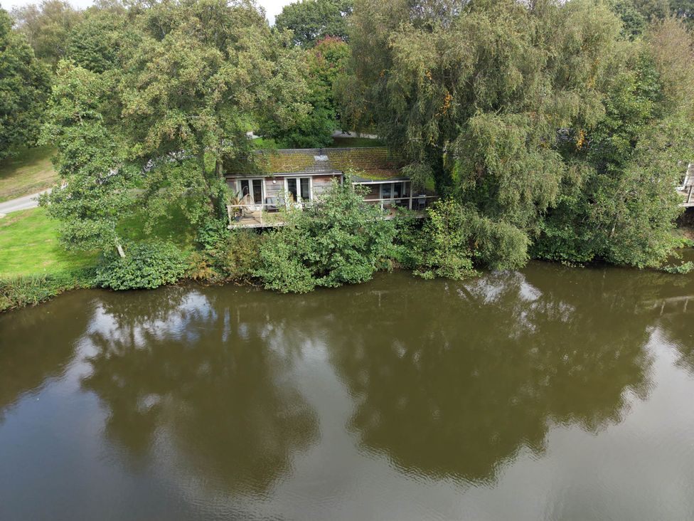 An outdoor area with a building near a body of water at 1 Water's Edge in Lanreath