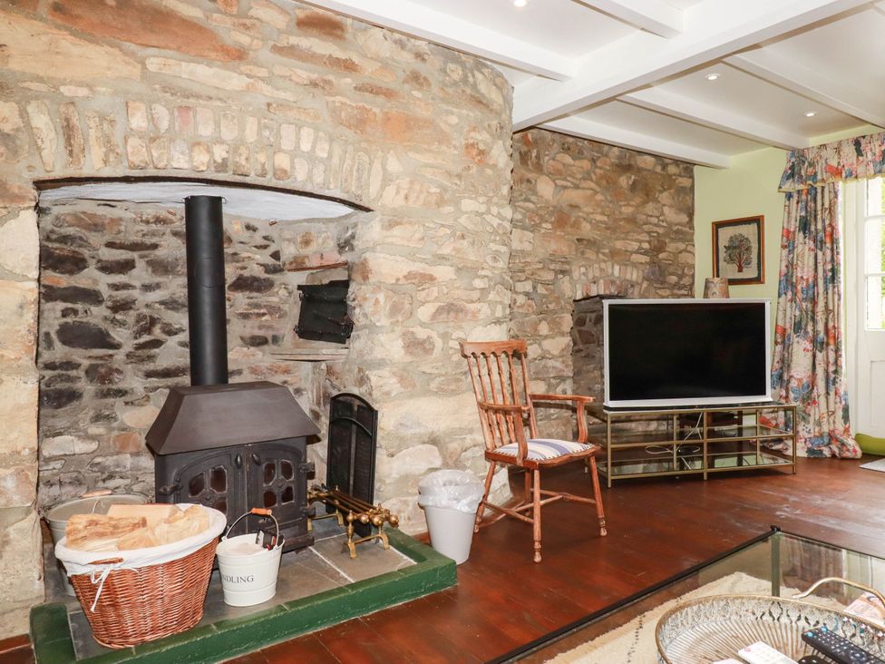 A living room with a wooden stove and television at The Homestead in 