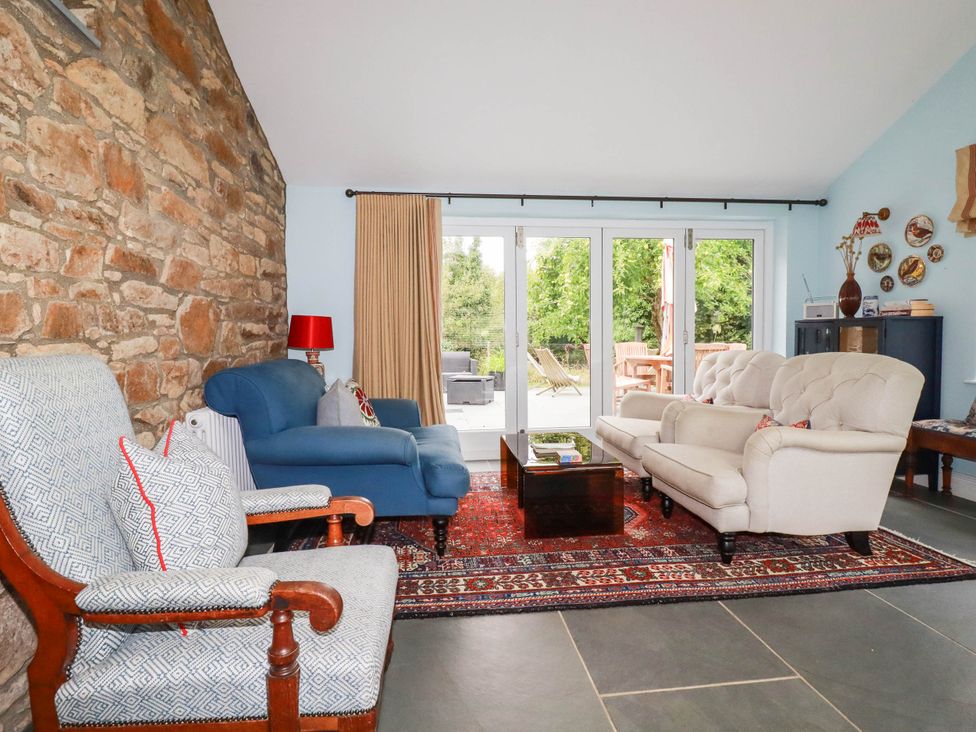 A living room with a stone wall and seating area at The Homestead in 
