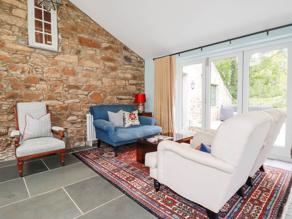 A living room with a blue sofa and stone walls at The Homestead 