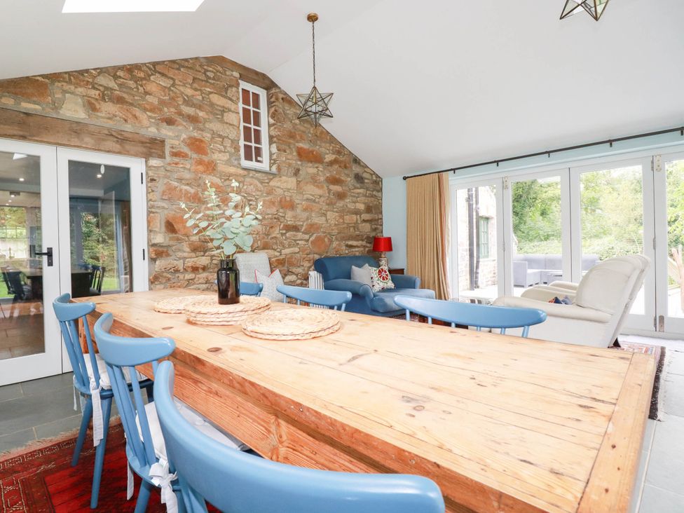 A dining room with a wooden table and chairs at The Homestead