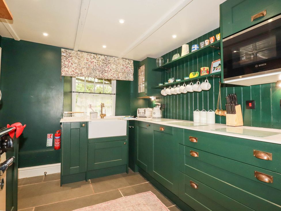 A kitchen with green cabinets and a large sink at The Homestead