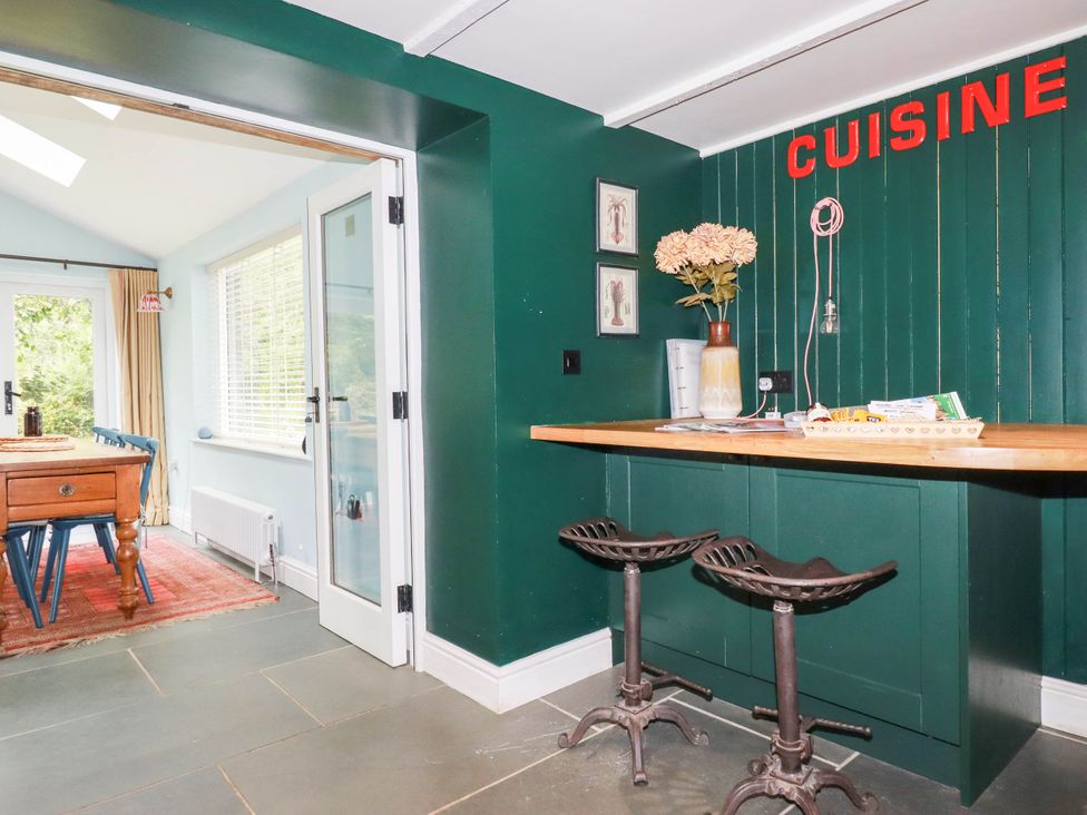 A kitchen with a counter and bar stools at The Homestead 